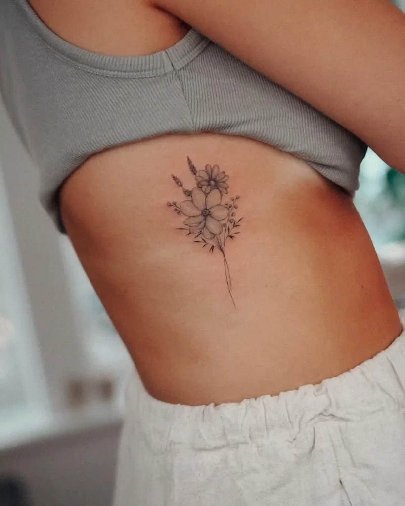 Simple Wildflower Sprig Ribcage Tattoo