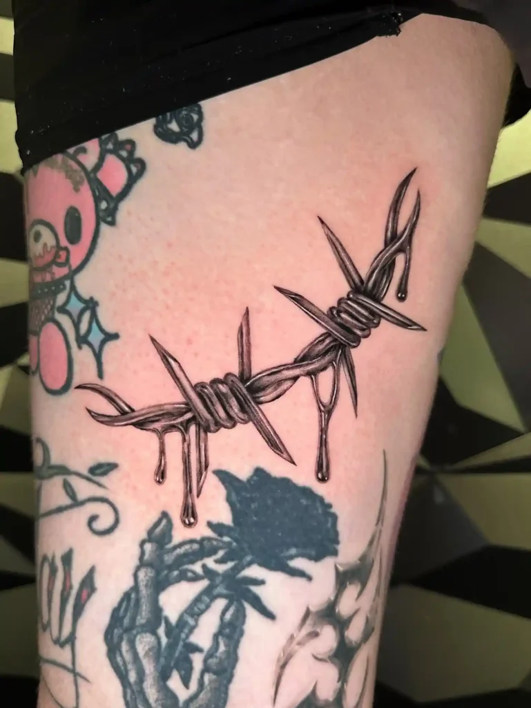 Chrome Barbed Wire with Liquid Droplets on Upper Thigh