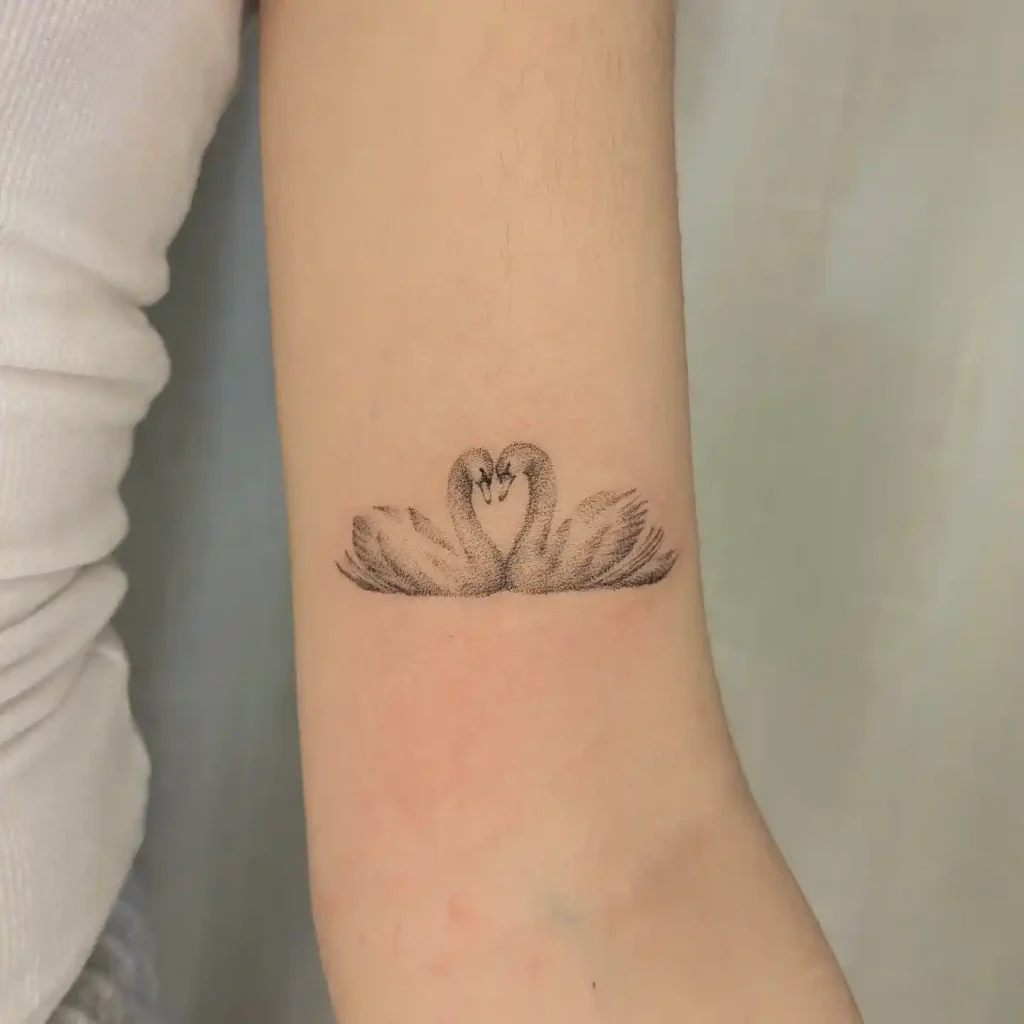 Twin Swans Forming Heart on Inner Arm