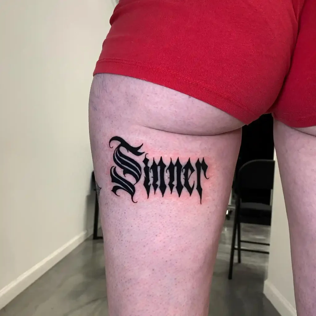 Bold Gothic Sinner Script on Thigh