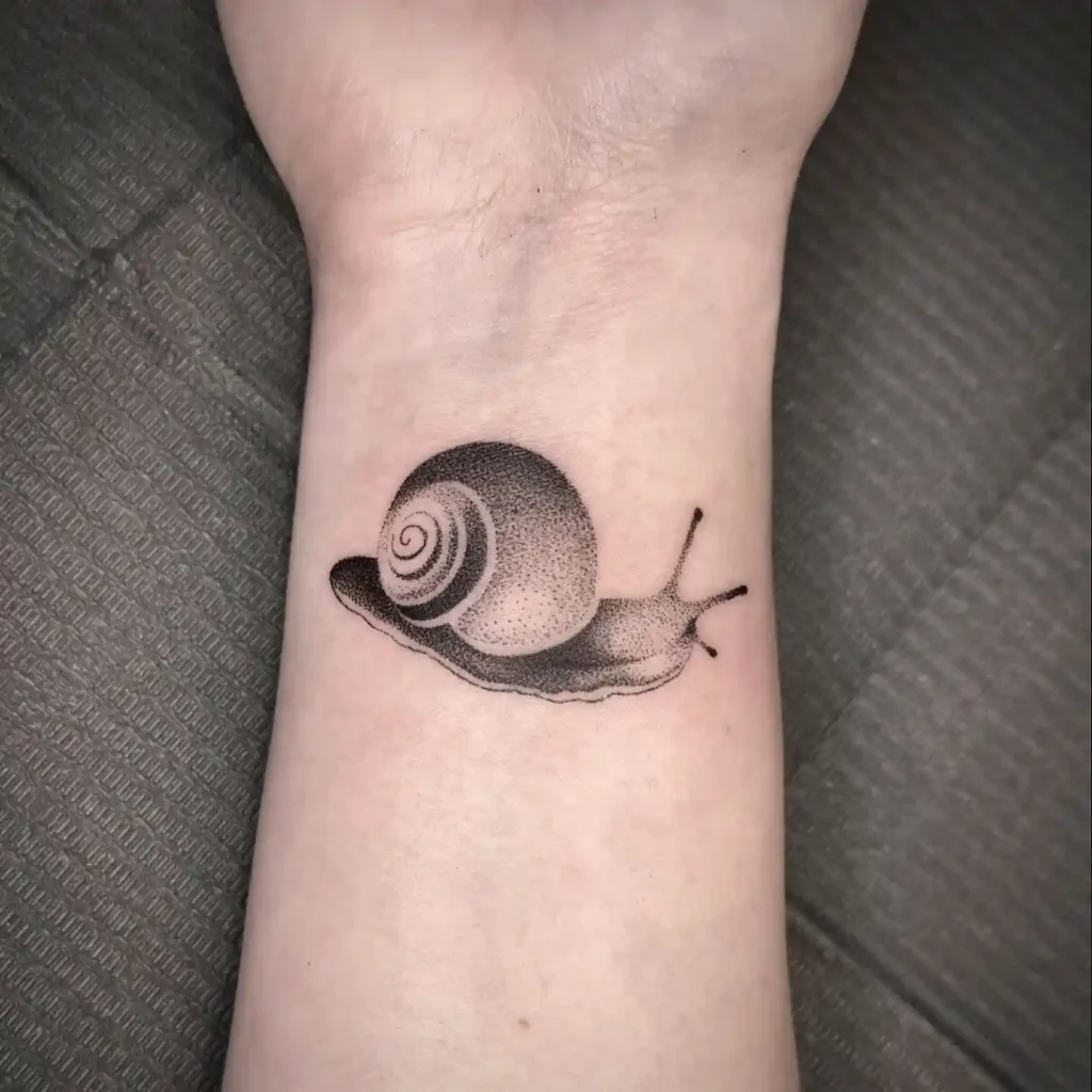 Minimalist Snail Tattoo on Inner Wrist
