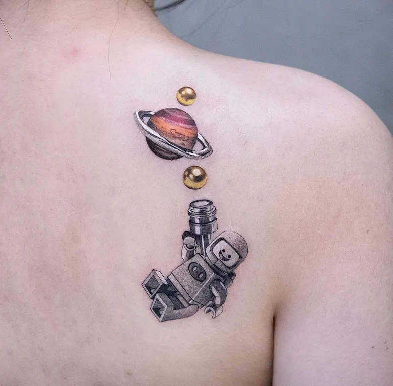 Floating Astronaut Lego Tattoo With Planet Detail