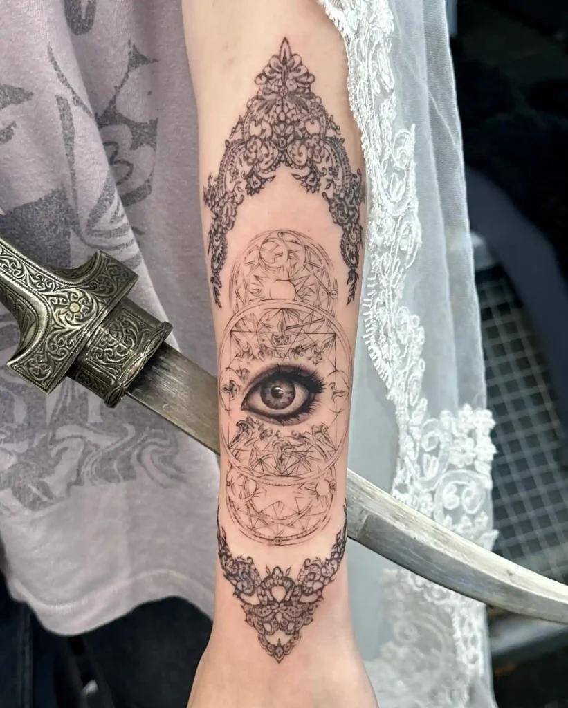 Geometric Eye and Ornate Lace Borders on Inner Forearm