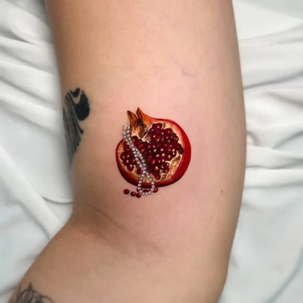 Realistic Sliced Pomegranate and Pearl Chain on Inner Arm