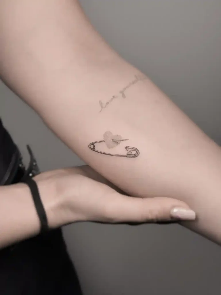 Safety Pin with Heart Tattoo on Inner Forearm