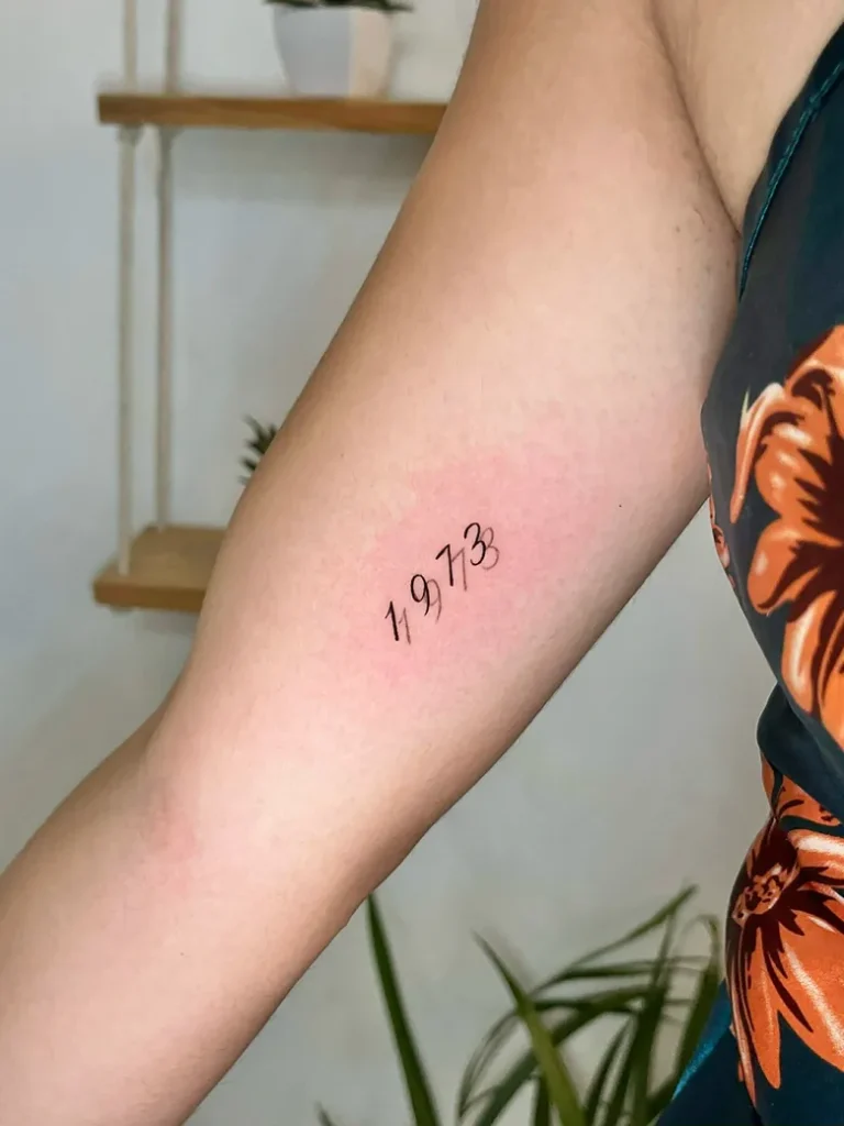Script Number Birth Year Tattoo on the Inner Arm