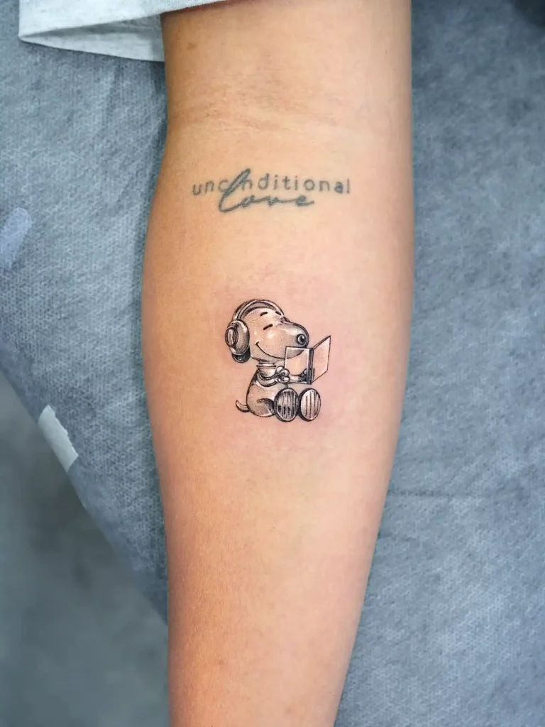 Snoopy Wearing Headphones and Reading on Forearm
