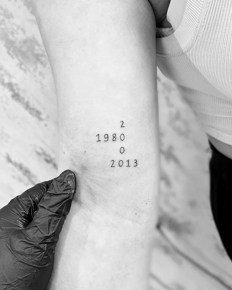 Vertical Number Birth Year Tattoo Near the Elbow
