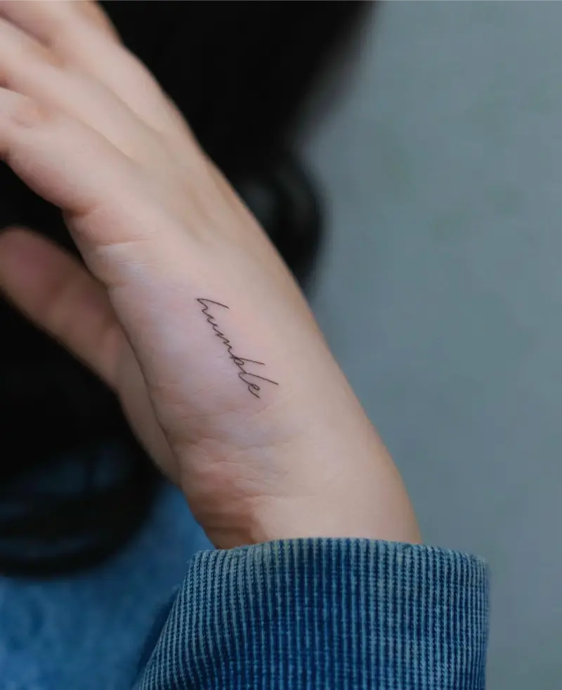 Fine Line Humble Script Hand Tattoo