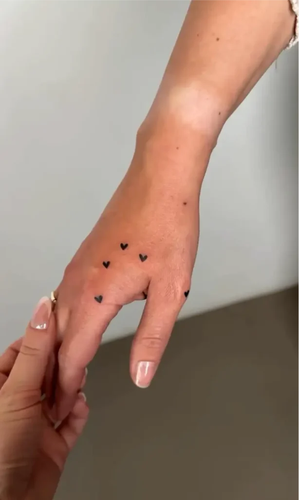 Hand Holding Heart Tattoo