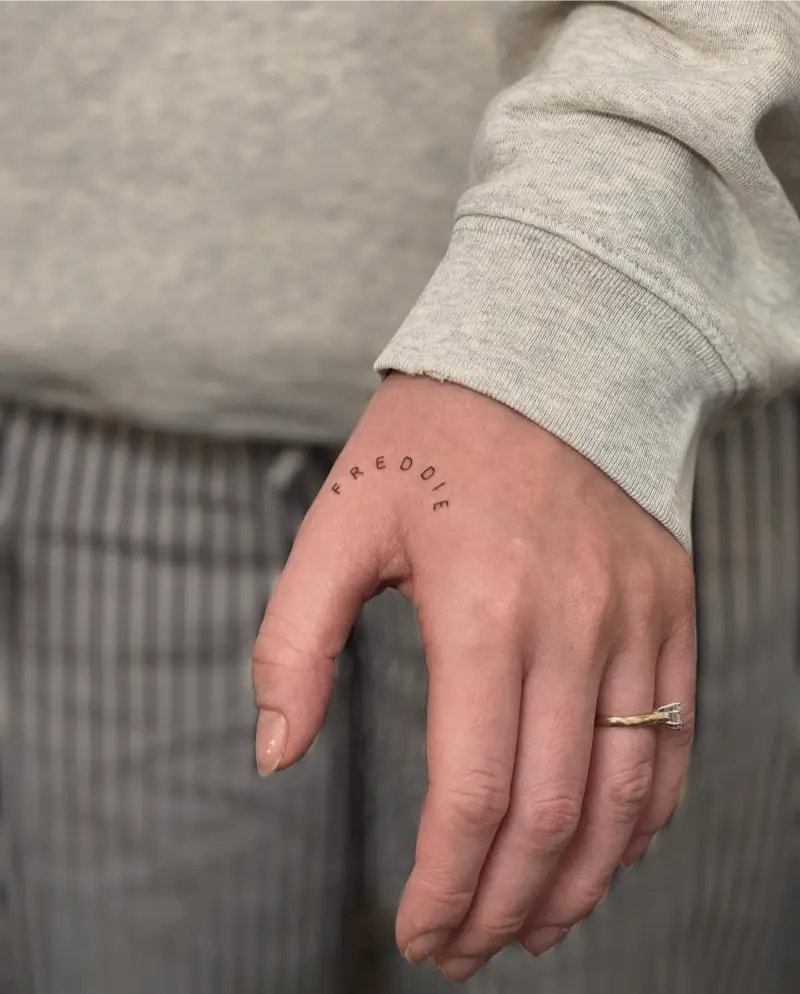Minimalist Curved Name Hand Tattoo