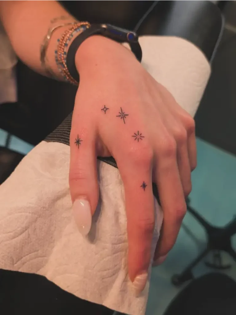 Minimalist Star Cluster Hand Holding Tattoo