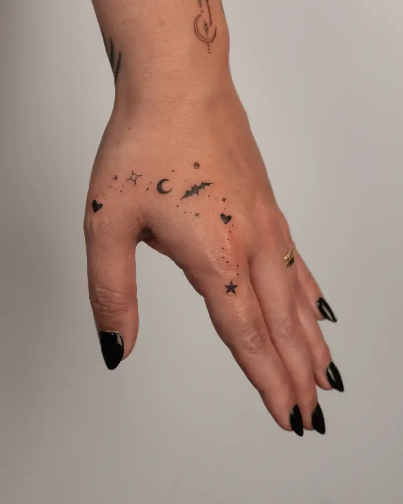 Whimsical Celestial Micro Hand Holding Tattoo