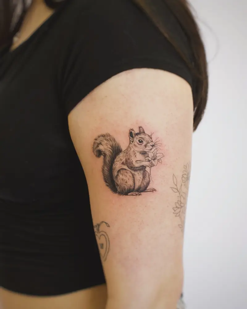 Delicate Flower Holding Squirrel Tattoo
