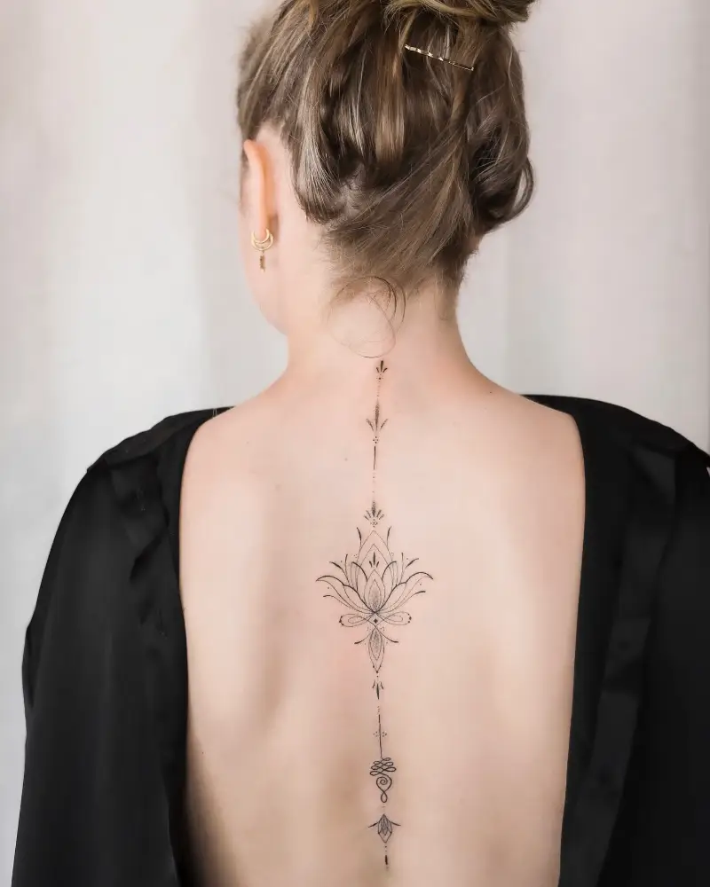 Minimalist Sacred Lotus Spine Tattoo