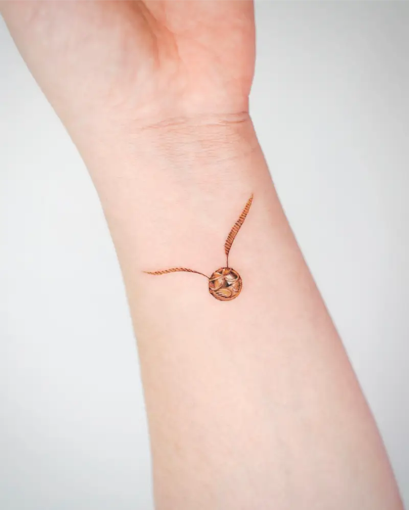 Tiny Golden Snitch Tattoo